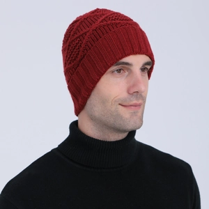 Detail of red knit beanie featuring thick textured weave and ribbed ear protection flaps