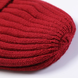 Close-up of bright red ribbed knit winter hat showing warm wool texture and stitching