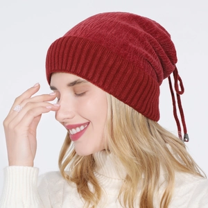 Detail of burgundy ribbed knit beanie showing soft texture and drawstring with metal tips