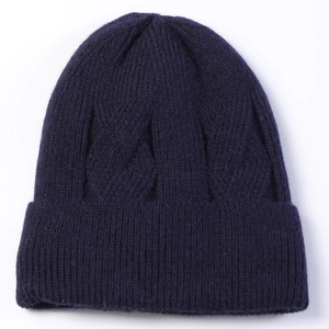 Detailed close-up of dark blue cable knit beanie showing thick ribbed texture and fleece lining