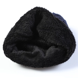 Detail of dark blue knitted winter hat featuring thick black faux fur thermal lining