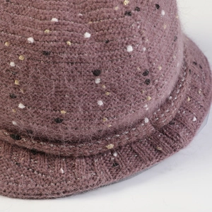 Détail macro d'un chapeau cloche en maille pelucheuse avec fils métalliques et pois colorés