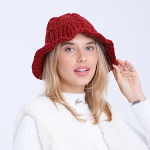 Close-up of red chunky knit bucket hat showing detailed crochet texture and wavy brim