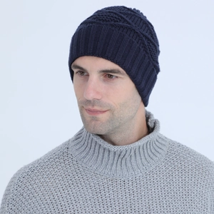 Detail of navy blue knit beanie showing thick ribbed cuff and textured geometric weave