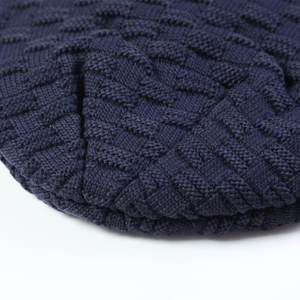 Detailed macro view of the navy blue knit beanie featuring a geometric square pattern