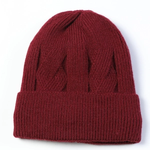 Close-up of wine red cable knit beanie showing thick ribbed texture and warm yarn detail