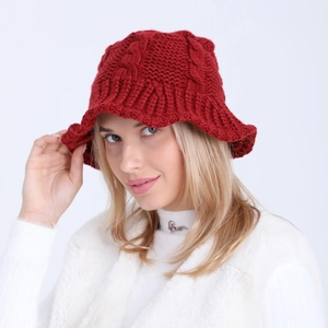 Close-up of deep red cable-knit bucket hat showing thick woolen texture and craft detail