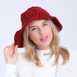 Detail of red cable-knit bucket hat showing the thick wool texture and intricate pattern