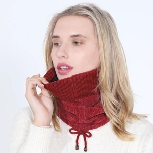 Close-up of wine red knitted neck warmer with ribbed texture and decorative drawstring bow