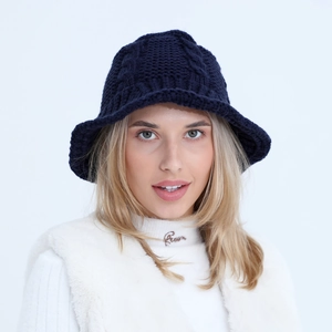 Close-up of chunky twist knit texture on a navy blue winter bucket hat for women