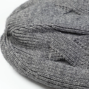 Macro shot of grey cable knit texture and soft thermal lining on winter beanie hat