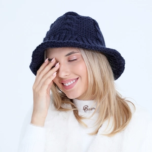 Close-up of deep blue knitted bucket hat showing coarse knit texture and warm yarn detail