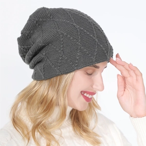 Macro shot of dark grey knit beanie featuring classic diamond pattern and warm texture