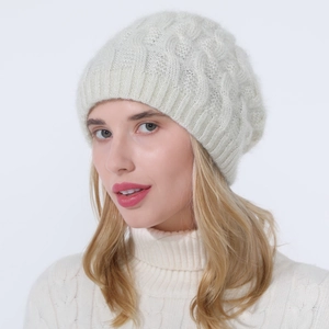 Close-up of beige knit beanie with cable pattern and subtle shimmer on a model