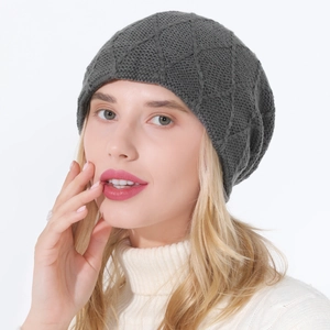 Detail of dark grey knit beanie with diamond pattern texture on a soft wool blend fabric