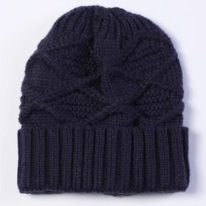 Close-up of dark blue knit beanie showing diamond patterns and ribbed cuff texture