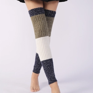 Detail of three-color patchwork cable knit leg warmers with vertical ribbing texture