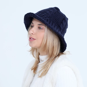 Detail of navy blue cable knit bucket hat showing textured wool pattern and warm fabric