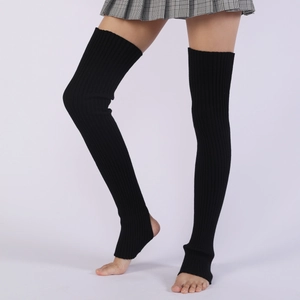 Detail of black ribbed knit over-knee leg warmers with stirrup design for yoga