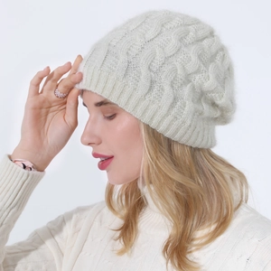 Close-up of beige knit beanie featuring silver glitter yarn and classic cable patterns
