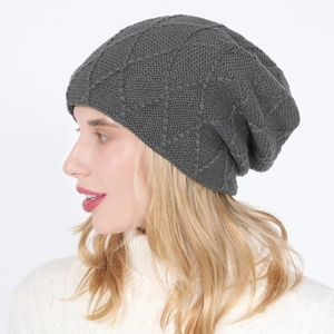 Detail shot of dark grey knitted beanie featuring textured diamond pattern on model