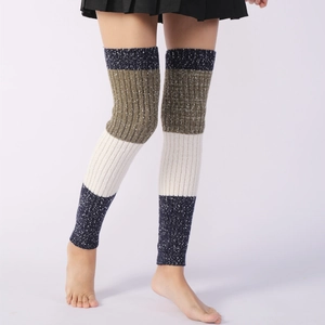 Macro detail of tricolor knit leg warmers with snowflake pattern and ribbed texture