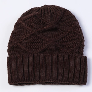 Close-up of deep brown chunky knit beanie with textured cable pattern and ribbed cuff