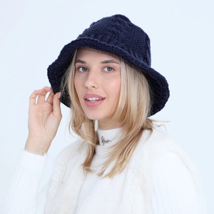 Detailed close-up of navy blue cable knit bucket hat with thick wool texture