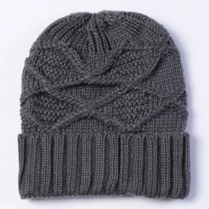 Detailed view of dark grey knitted beanie with cross relief texture and ribbed cuff