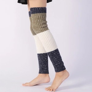 Close-up of color-block knit leg warmers showing thick ribbed texture and warm yarn detail