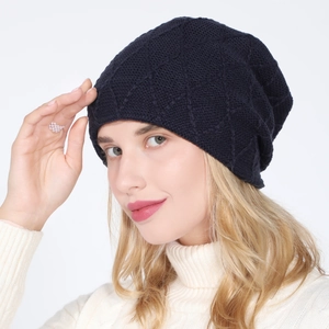 Close-up of deep blue knitted slouchy beanie with diamond lattice texture and warm lining
