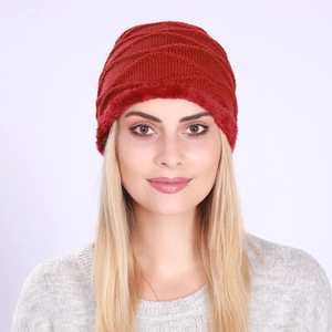 Close-up of red cable knit hat with thick faux fur lining for winter warmth