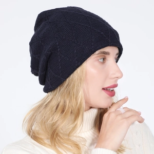 Detail view of black knit beanie with diamond pattern texture on a side-view model