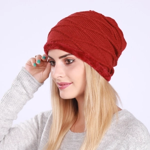Close-up of red pleated knit beanie with thick faux fur lining for winter warmth
