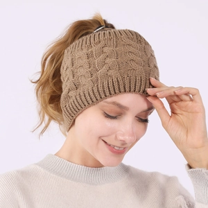 Detail of warm coffee cable knit messy bun beanie with elastic ribbed texture