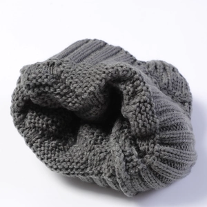 Close-up of thick knit texture and ribbed edge of a dark grey winter pullover hat