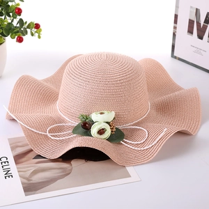 Pink wide brim straw sun hat with wavy edges and floral bow decoration for women