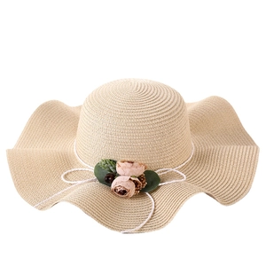 Women's wide brim straw sun hat with flower accents and elegant wavy edge design