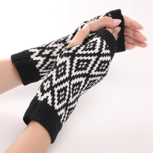 Detailweergave van zwart-witte ruitvormige gebreide armwarmers zonder vingers