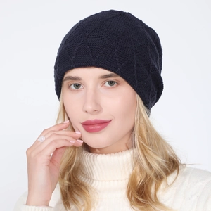 Detail of navy blue knit beanie showing diamond lattice pattern and warm texture