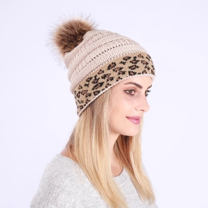 Detailed knit texture and leopard print cuff on a beige winter pom-pom beanie