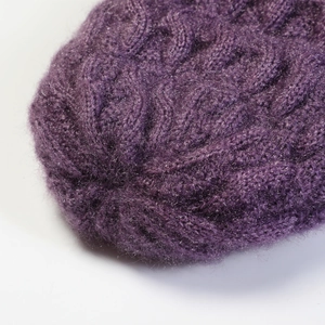 Close-up detail of purple cable-knit wool beanie showing soft mohair texture and patterns