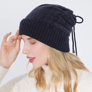 Detailed knit texture of navy blue beanie with adjustable drawstring and metal buckle
