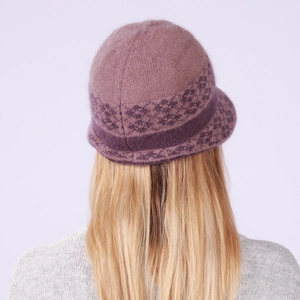 Detail view of pink winter knit hat featuring plush texture and purple geometric pattern