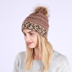 Detail of a brown leopard print knitted beanie featuring a fluffy faux fur pom-pom