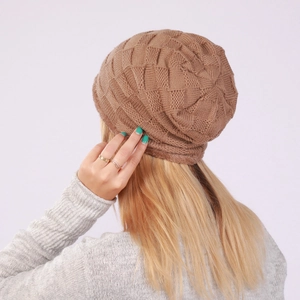 Detailed view of brown checkered knit beanie with warm fleece lining on a blonde model