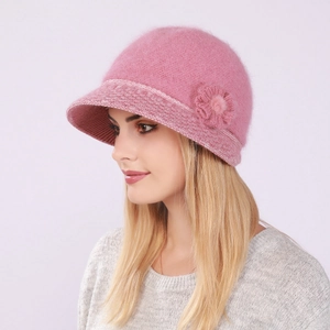 Detail view of pink knitted winter bucket hat with side flower and soft warm fur texture