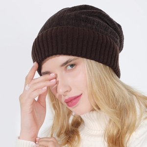 Detail of dark brown knit beanie showing thick ribbed texture and slouchy fit on model