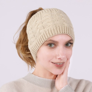 Detail of cable knit headband in beige showing the thick woven texture and elastic ribbing