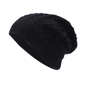 Detail view of thick black knit beanie showing diamond patterns and ribbed texture for winter